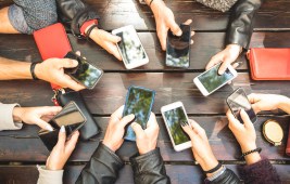 people holding phones at table