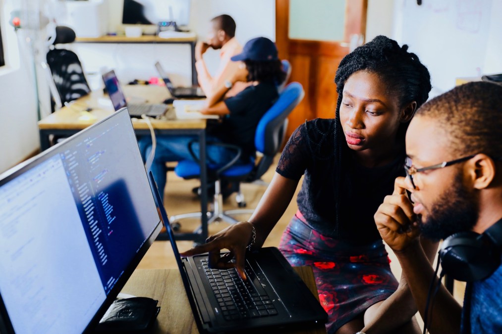 man and woman coding in computer lab